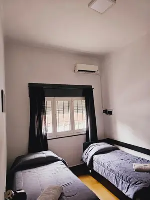 a bedroom with two beds and a window at LitStay Paso de los Andes PB in Cordoba