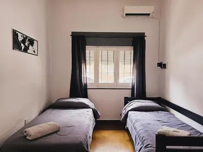 two beds in a room with a window at LitStay Paso de los Andes PB in Cordoba
