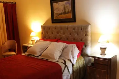a bedroom with a bed with red sheets and white pillows at Casa Alberdi in Cordoba