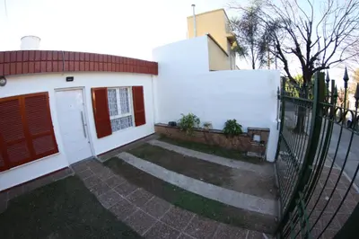 a white house with a gate and a fence at Casa Alberdi in Cordoba