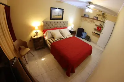 a bedroom with a red bed with a red blanket at Casa Alberdi in Cordoba