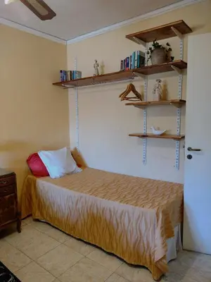 a bedroom with a bed and shelves on the wall at Casa Alberdi in Cordoba