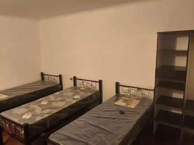 a room with two beds and a shelf at La Casa de Elisa in Santa Rosa de Calamuchita