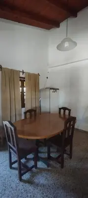 a wooden table and chairs in a room at La Casa de Elisa in Santa Rosa de Calamuchita