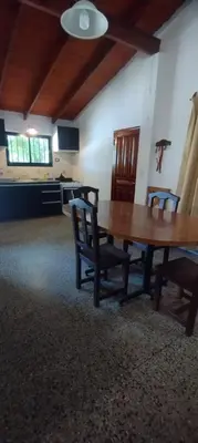 a dining room with a wooden table and chairs at La Casa de Elisa in Santa Rosa de Calamuchita