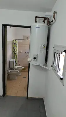 a bathroom with a toilet and a window and a mirror at La Casa de Elisa in Santa Rosa de Calamuchita