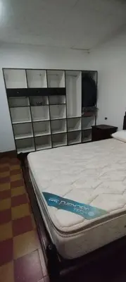 a bed in a room with some shelves at La Casa de Elisa in Santa Rosa de Calamuchita