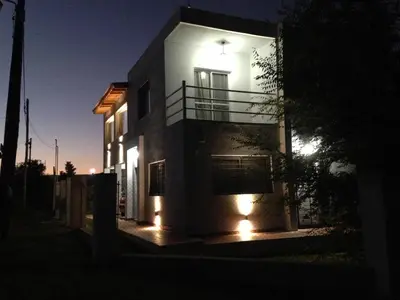 a house with lights on the side of it at night at Apartamentos Anahí in Villa Parque Siquiman