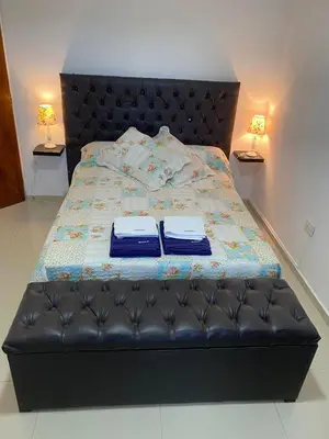 a bedroom with a bed with two robes on it at Apartamentos Anahí in Villa Parque Siquiman