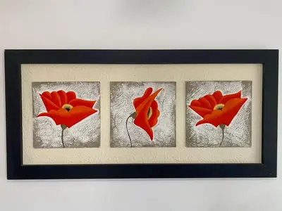 a picture of four red flowers in a frame at Apartamentos Anahí in Villa Parque Siquiman