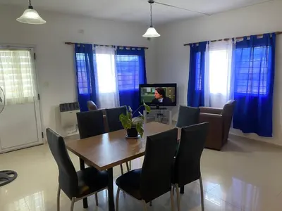 a dining room with a table and chairs and a television at Apartamentos Anahí in Villa Parque Siquiman