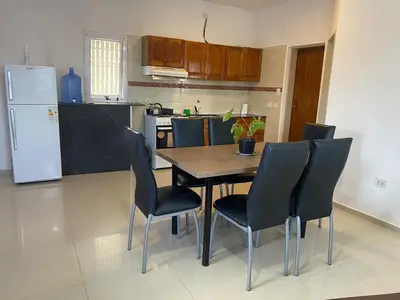 a kitchen with a table and chairs and a refrigerator at Apartamentos Anahí in Villa Parque Siquiman
