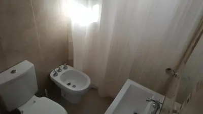 a bathroom with a white toilet and a sink at Ayres de Merlo Aparts in Merlo