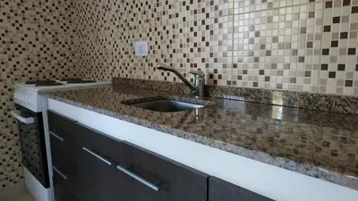 a bathroom with a sink and a tiled wall at Ayres de Merlo Aparts in Merlo