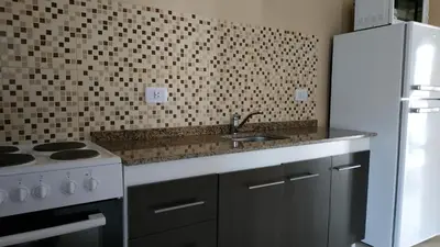 a kitchen with a sink and a stove at Ayres de Merlo Aparts in Merlo
