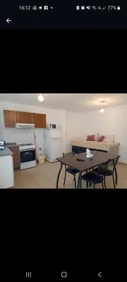 a living room with a table and a kitchen at Apartamentos Santa Rosa PB 1 in Cordoba