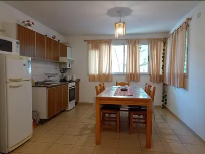 a kitchen with a table with chairs and a refrigerator at Apartamentos Santa Rosa PB 1 in Cordoba