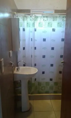 a bathroom with a sink and a shower curtain at El Amanecer in Santa Rosa de Calamuchita