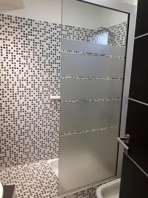 a shower with a glass door in a bathroom at Departamento Torre Sofitel in Río Cuarto