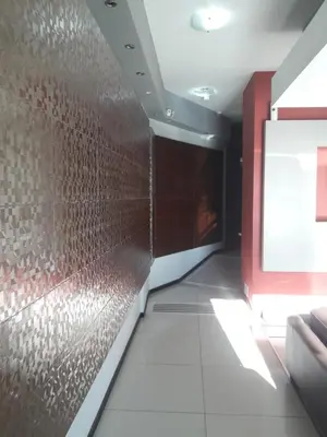 a hallway with a red wall and a tile floor at Departamento Torre Sofitel in Río Cuarto