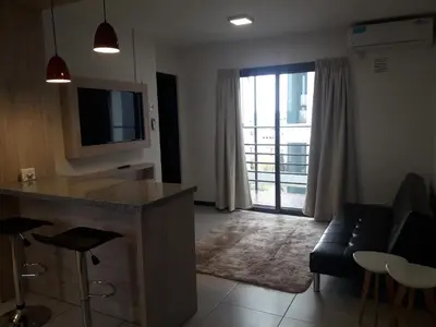 a living room with a couch and a tv and a table at Departamento Torre Sofitel in Río Cuarto