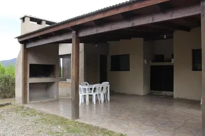 a patio with two white chairs and a table at Postal de las Sierras in Santa Rosa de Calamuchita