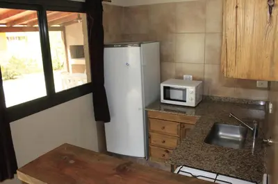 a kitchen with a white refrigerator and a microwave at Postal de las Sierras in Santa Rosa de Calamuchita