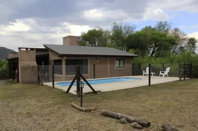 a house with a swimming pool in front of a house at Postal de las Sierras in Santa Rosa de Calamuchita