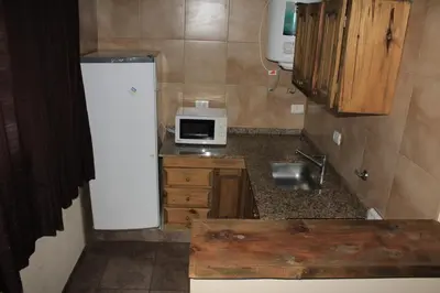 a small kitchen with a refrigerator and a microwave at Postal de las Sierras in Santa Rosa de Calamuchita