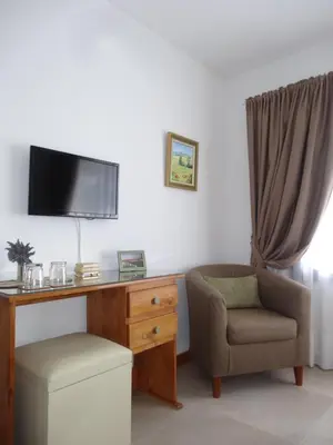a living room with a desk and a chair and a tv at Le Bel-Edén in Villa General Belgrano