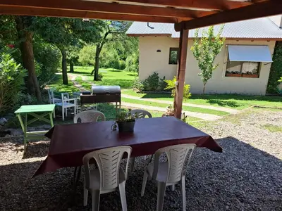 a table and chairs sitting under a pergola at Le Bel-Edén in Villa General Belgrano