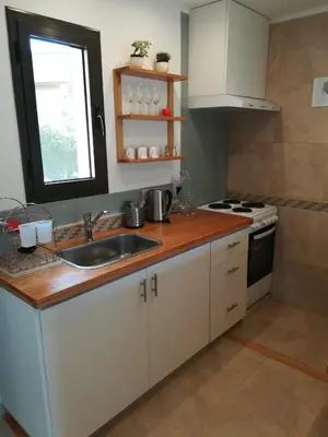 a kitchen with white cabinets and a sink and a window at Le Bel-Edén in Villa General Belgrano