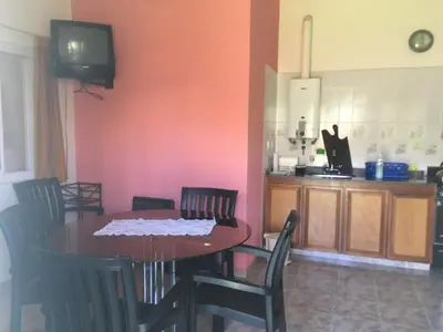 a dining room with a table and chairs and a tv at Departamento Carlos paz in Villa Carlos Paz
