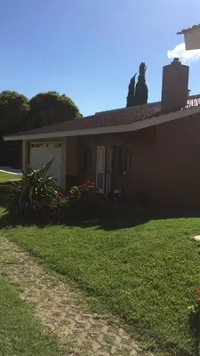 a house with a green lawn in front of it at Departamento Carlos paz in Villa Carlos Paz