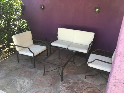 two white chairs sitting next to a purple wall at Departamento Carlos paz in Villa Carlos Paz