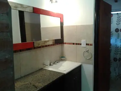a bathroom with a sink and a mirror at Cabañas Santa Isabel in Santa Rosa de Calamuchita