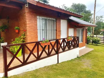 a house with a fence and some plants on it at Cabañas Santa Isabel in Santa Rosa de Calamuchita