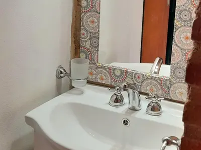 a bathroom with a white sink and a mirror at Cabañas Santa Isabel in Santa Rosa de Calamuchita