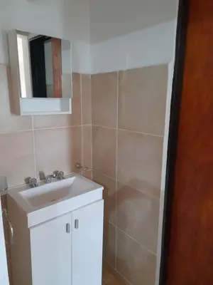 a bathroom with a white sink and a mirror at Cabañas Santa Isabel in Santa Rosa de Calamuchita