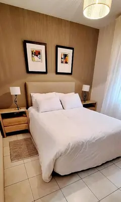 a bedroom with a large white bed with two night stands at Tranquilo, comodo y cerca de todo in Cordoba