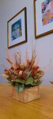 a flower arrangement in a wooden box on a table at Tranquilo, comodo y cerca de todo in Cordoba