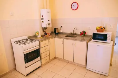 a kitchen with a white stove and a microwave at Tranquilo, comodo y cerca de todo in Cordoba