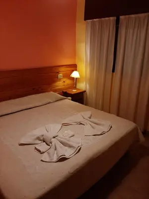 a bedroom with a bed with a robe on it at Residencial Sol del Champaqui in Mina Clavero