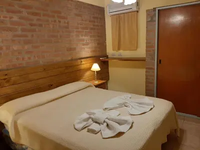 a bedroom with a bed with towels on it at Residencial Sol del Champaqui in Mina Clavero