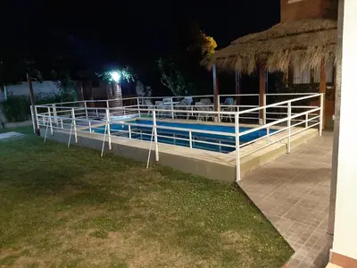a swimming pool at night with a roof at Residencial Sol del Champaqui in Mina Clavero