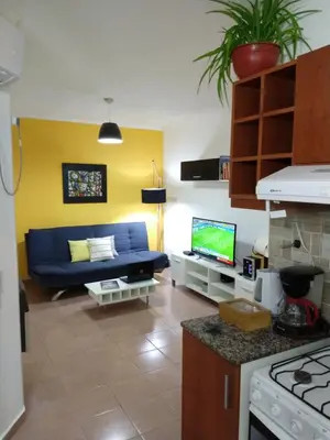 a living room with a blue couch and a tv at De pasadita in Cordoba
