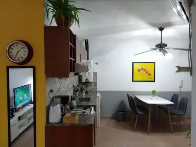 a kitchen and dining room with a table and a clock at De pasadita in Cordoba