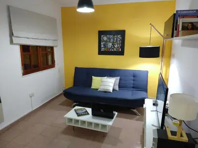 a living room with a blue couch and a table at De pasadita in Cordoba
