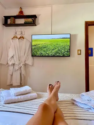 a person laying on a bed with their feet on a television at Rincón de Paz Apart & Loft Suite Boutique - Adults Only in Villa Carlos Paz