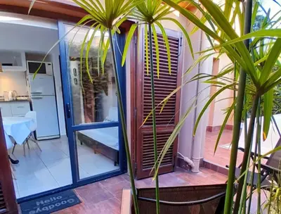 a house with a glass door and a palm tree at Rincón de Paz Apart & Loft Suite Boutique - Adults Only in Villa Carlos Paz